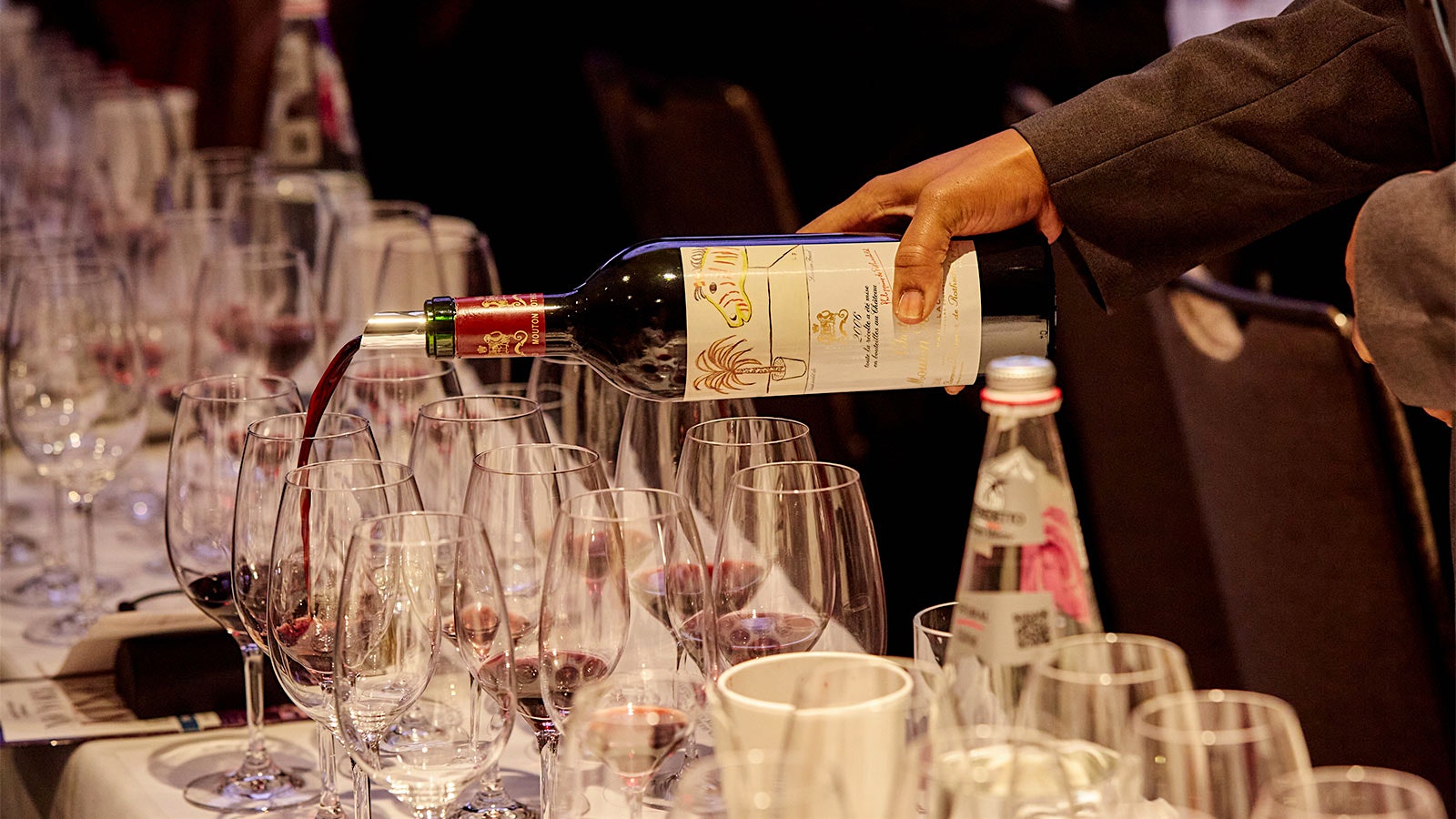     A server pours a bottle of Château Mouton-Rothschild 2006 with an artist label by Lucien Freud for a guest at the New York Wine Experience 2022